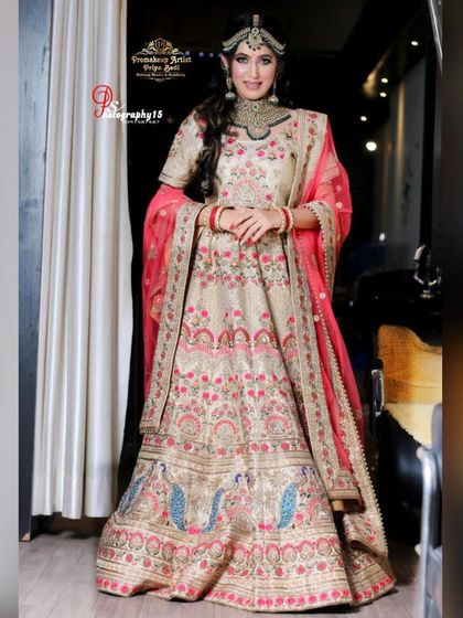 A beautiful beige lehenga with pink and blue peacock embroidery. This is a lighter, more subtle option for a bride who prefers pastel shades for her wedding day.
