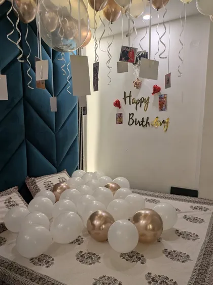 For a personal touch, I hang photos from helium balloon ribbons. This birthday room decoration uses this technique to display cherished memories, making the surprise even more meaningful.