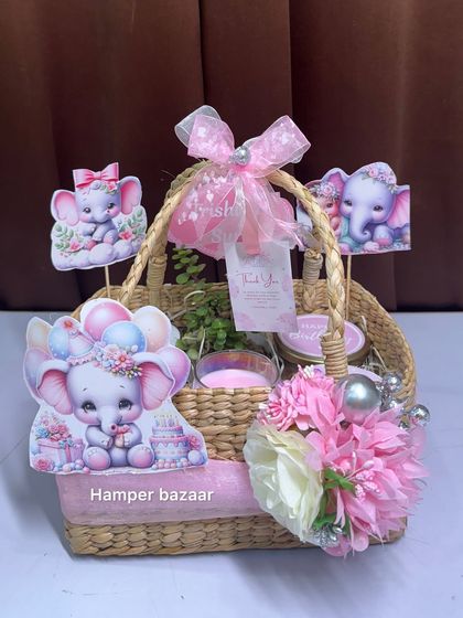 A close-up of the cona basket hamper, decorated with pink flowers, pearl strings, and multiple elephant cutouts.