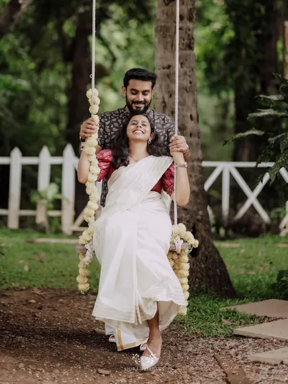 A joyful couple on a flower-adorned swing, a whimsical and romantic detail that adds a touch of magic to their pre-wedding shoot.