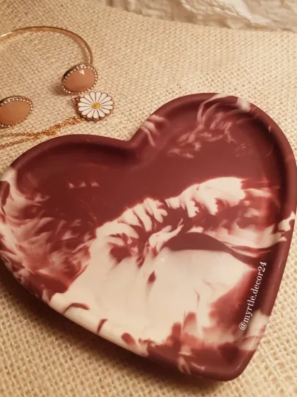 Our Aurora Heart Tray, shown empty to highlight the beautiful, dramatic swirls of the maroon and white marble.