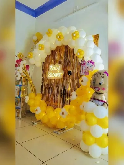 If you want something different from the usual pink and blue, I can create themes with any color. This baby shower decor uses a cheerful yellow and white palette for the balloon arch, complete with a neon sign and cute baby foil balloons.