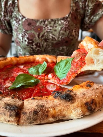 A customer enjoying a slice of our Marinara pizza. The smile says it all.