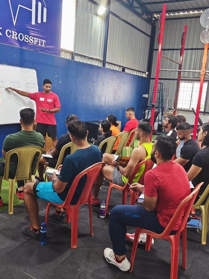 A lecture portion of a CrossFit Level 1 seminar, with a coach explaining concepts at the whiteboard to an attentive class.