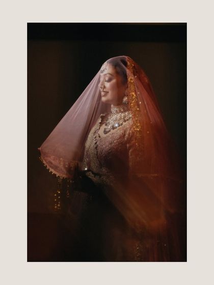 An artistic portrait of bride Radhika, with her veil creating a soft, ethereal blur. This shot uses motion and light to create a dreamy and romantic effect.