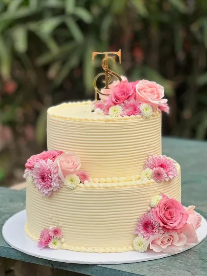 I love bringing your grand celebrations to life. This two-tiered custom cake, adorned with fresh pink roses and chrysanthemums, was designed to be an elegant centerpiece for a very special day.