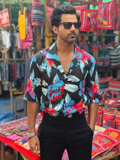 Escape the ordinary with our resort wear collection. This black floral shirt with a vibrant blue and red pattern is perfect for vacation evenings and tropical getaways.