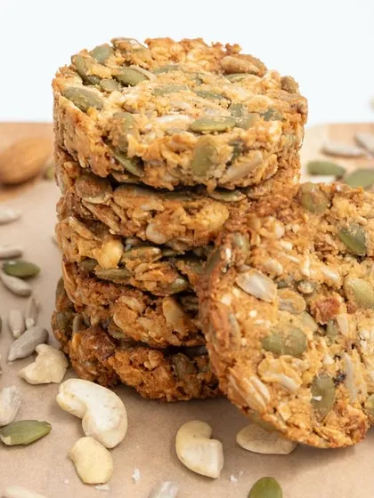 Another angle of the stacked 7-Seeds Nuts Cookies on a wooden board, emphasizing their homemade, artisanal quality.