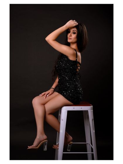 A glamorous party look captured in the studio. The sequined dress and confident pose create a sophisticated and elegant image, ideal for a formal wear or evening fashion portfolio.