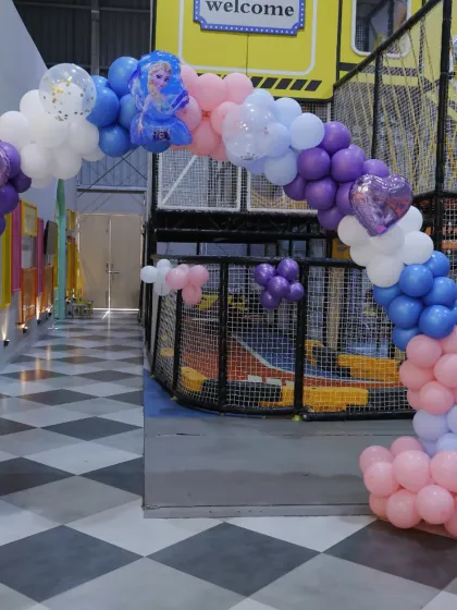 A 'Frozen' themed balloon archway leading into the play area. The mix of character balloons and sparkling details adds to the enchanting wintery feel.