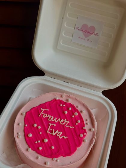 A vibrant pink bento cake with a textured center and pearl details. The 'Forever Eva' message makes it a personal and heartfelt gift.