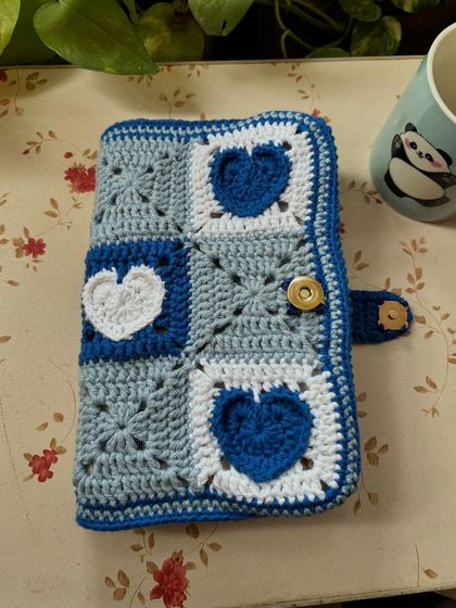 Our heart book cover in shades of blue. The granny squares are arranged in a lovely pattern of alternating colors.