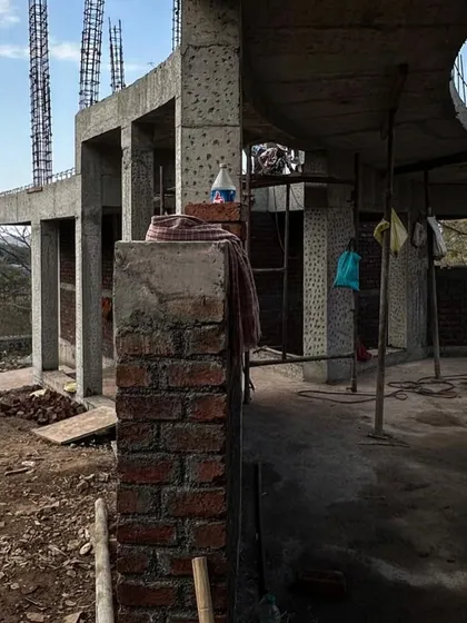 The raw concrete and brick structure of an Alibaug house. This behind-the-scenes view shows the bones of the building before the finishing materials are applied.