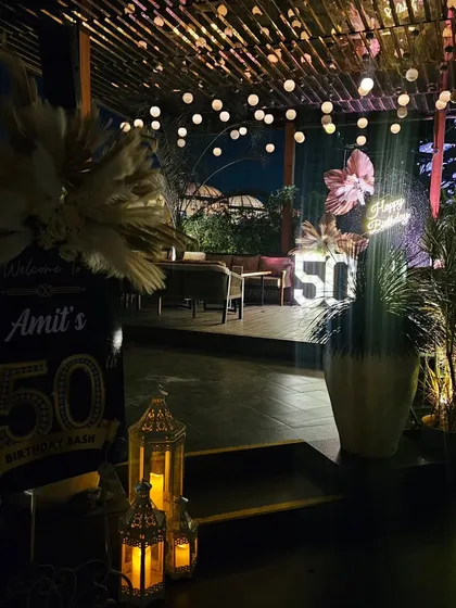 The entrance to Amit's 50th birthday bash, showing the welcome sign and a glimpse of the main decor in the background. We focus on creating a seamless experience from the moment guests arrive.