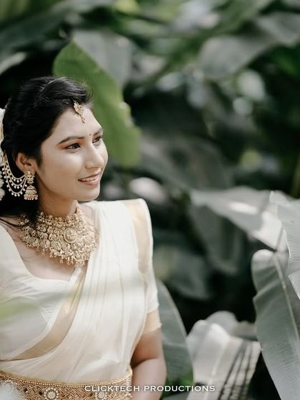A classic three-quarter portrait of the bride-to-be, her traditional jewelry and attire highlighted against a green backdrop.