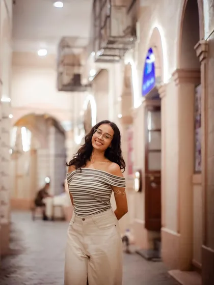 A standing portrait that captures the warm, inviting atmosphere of the location. Her smile makes the photo feel very welcoming.