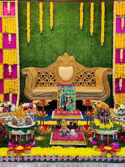 A colorful baby shower setup with a green, yellow, and pink marigold backdrop, creating a bright and cheerful atmosphere.