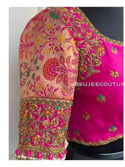 The front view of the pink brocade sleeve blouse. The combination of the plain pink body and the richly patterned brocade sleeve creates a beautiful contrast, tied together with matching embroidery.