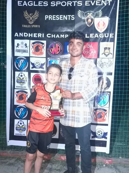 A player receives an award for his performance in the Andheri Champions League.