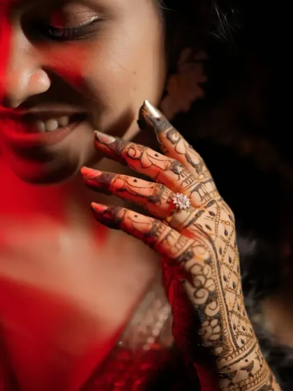 A close-up of a bride's hand, showing the intricate details of the design and the beautiful dark stain.