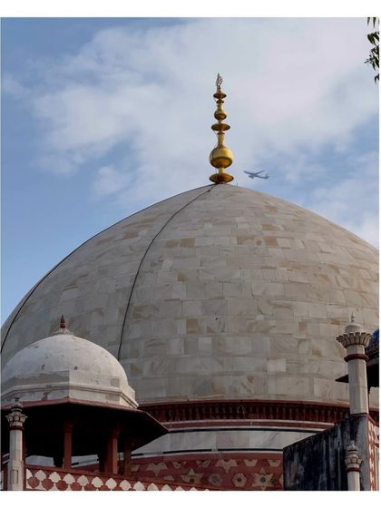 A close-up of the dome of Humayun's Tomb, with an airplane flying past in the sky. A perfect juxtaposition of the ancient and the modern.