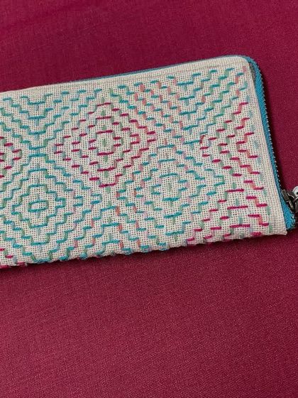 A finished zippered pouch with a geometric pattern. This versatile accessory can be used as a spectacle case, a mobile pouch, or a small wallet.