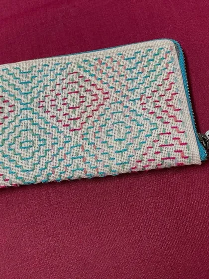 Another view of the hand-embroidered pouch. The durable canvas and sturdy zipper make it as practical as it is beautiful.