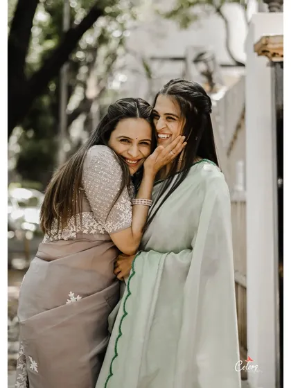 A candid moment of sisterly love and friendship during an engagement celebration.