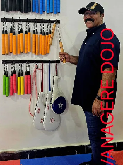 Me at our Davanagere dojo, standing by the nunchaku rack. We ensure all our branch dojos are well-equipped with the necessary traditional weapons for proper Kobudo training.