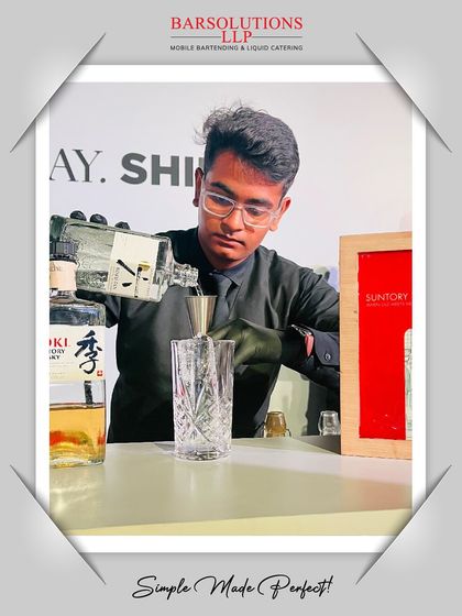 A bartender carefully measuring ingredients for the "Golden Glimmer" whisky cocktail at the Kerastase launch.