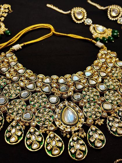 Rented for a day, remembered forever. This elaborate green Meenakari and Kundan bridal set, including necklace and matching earrings, is perfect for making a grand statement.