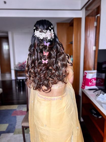 Hair tales with my beautiful bride Surbhi for her haldi. We created soft curls and added floral and butterfly clips for a whimsical touch.