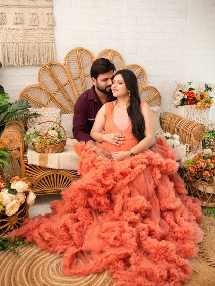 A slightly different angle of the couple on the boho set, showing more of the stunning ruffled gown and the cozy studio environment. Their gentle embrace tells a story of shared dreams.