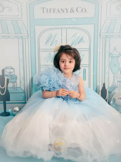 A serene portrait of a little girl in her blue gown, posing for her "Tiffany & Co." themed shoot.