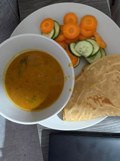 A comforting meal of dal, paratha, and a side of sliced carrots and cucumber. This is a balanced meal for our client focusing on inch loss.