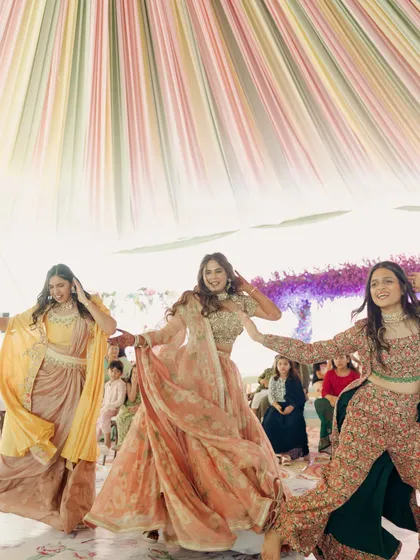 A trio of friends performing at a daytime event. The coordinated pastel outfits and energetic poses make for a lively and beautiful picture.