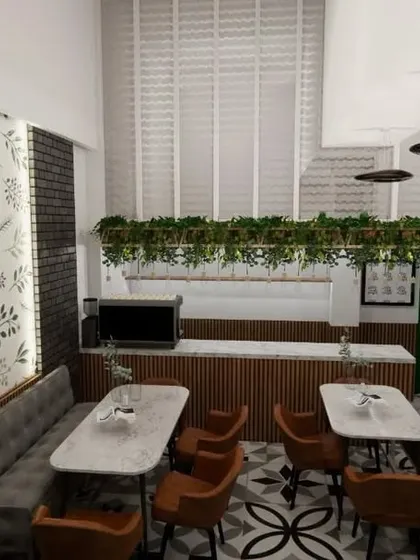 This view showcases the feature wall with a botanical wallpaper, which acts as a focal point and adds a fresh, organic feel to the cafe. The layout ensures a clear path to the service counter, which is framed by hanging greenery.