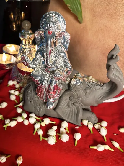 This silver-plated Ganesha idol, seated on a beautifully detailed elephant, is a symbol of auspiciousness. I designed it to be a centerpiece for your home temple, surrounded by fresh jasmine flowers.