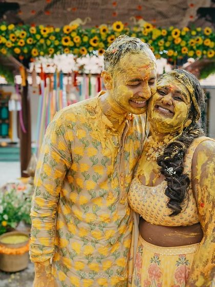 A happy couple covered in turmeric paste during their Haldi, sharing a laugh. Our courtyards are perfect for such fun-filled events.