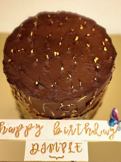 A tall, elegant chocolate and strawberry cake I made for a 50th birthday. The rustic ganache is speckled with edible gold leaf, and the name is handwritten in gold on a separate plaque for a personal touch.