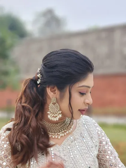 A side profile showing the details of the hairstyle and the soft, neutral makeup tones.