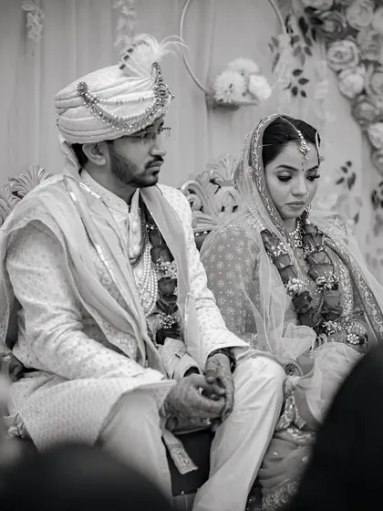 A solemn, candid moment from the wedding ceremony in black and white. This photo captures the traditional and serious aspects of the rituals.