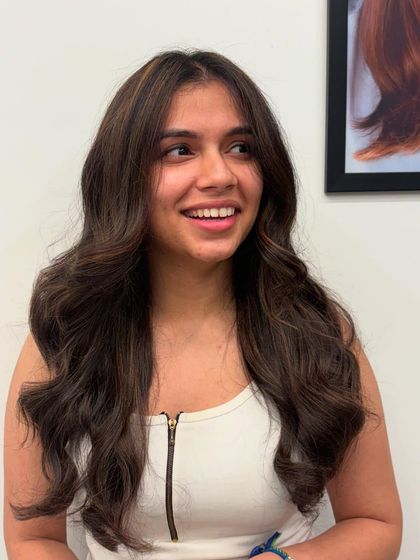 A happy client showing off her new subtle brown highlights. The color frames her face nicely and adds a warm glow.