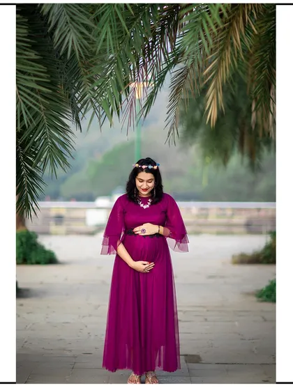 A full-length solo shot under a palm tree, capturing a moment of quiet anticipation.