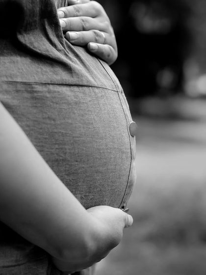 A timeless black and white close-up of a baby bump. This artistic shot focuses on the shape and texture, creating a simple yet profound image of motherhood.