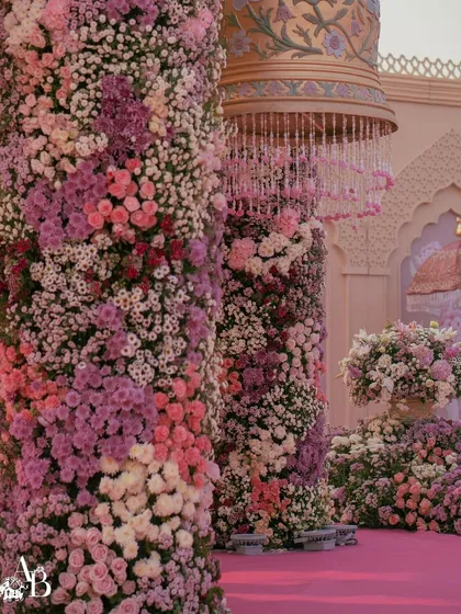 A ground-level view of the towering floral pillars, showing the density and variety of blooms used. We work with top floral designers to create structures that are both grand in scale and delicate in detail.