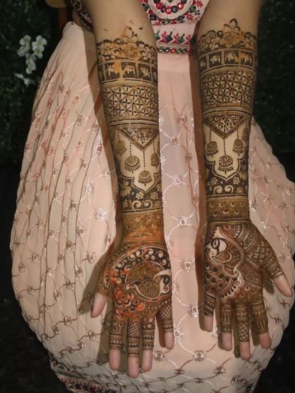 This grand bridal design features a procession of elephants on the forearms and majestic peacocks on the palms, creating a royal look.