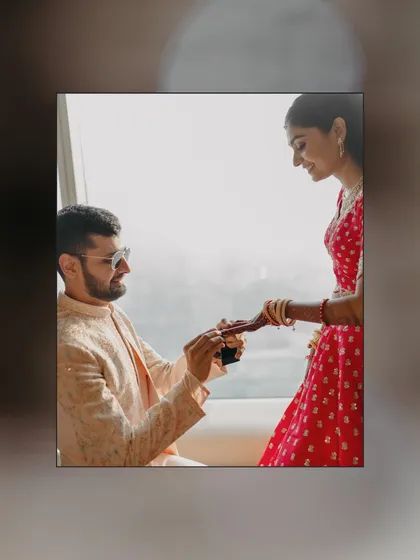 A sweet moment as the groom kneels to offer a gift to his bride while they get ready together. A beautiful, personal ritual before the main ceremony.