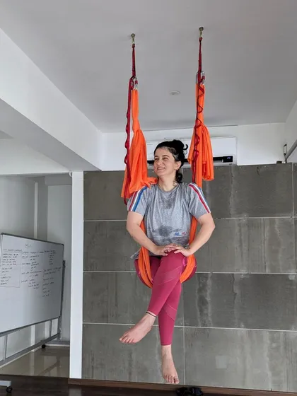 A relaxed and happy student in the aerial hammock, embodying the fun and accessible nature of our classes.