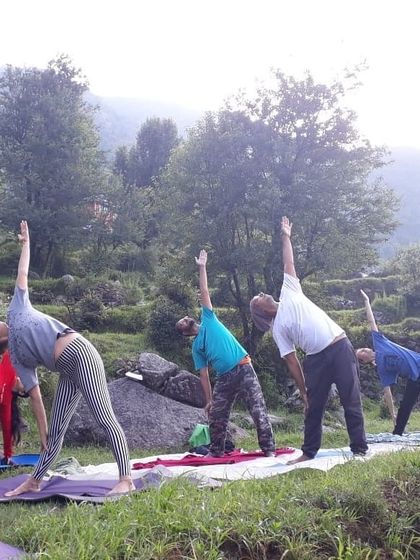 Guiding students through Trikonasana (Triangle Pose) during an outdoor session. My focus is on proper alignment and breathing for all participants.